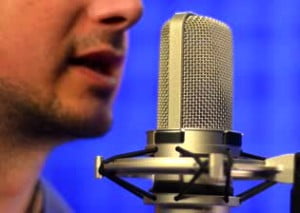 stock-footage-man-speaking-into-studio-microphone-mid-close-up-shot